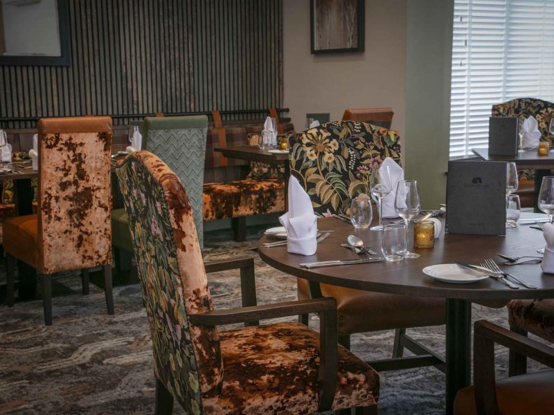 Orange and brown restaurant seating with brown wooden tables