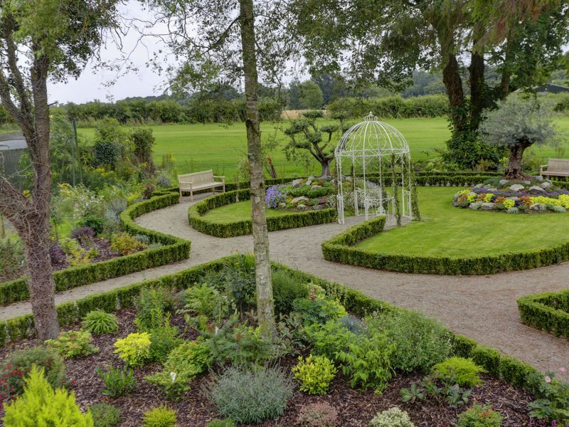 Level gardens with concrete pathways leading around the green shrubary