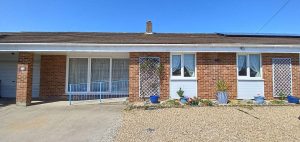 Red brick suburban home with solar panels and garage.