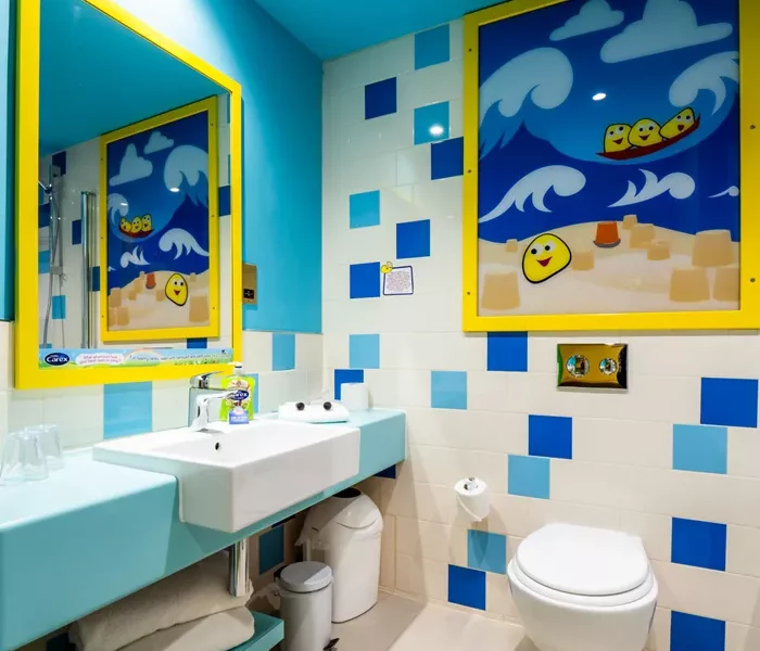 A blue and yellow themed ensuite with white,dark blue and light blue tiles on the wall.