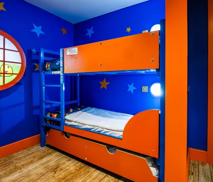 an orange bunk bed against a blue wall