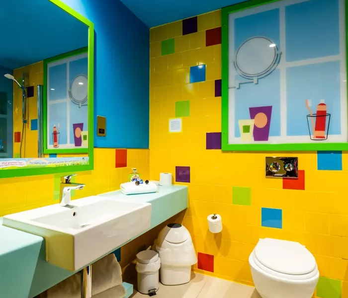 a bright ensuite bathroom with yellow,blue,green,orange and purple tiles on the wall