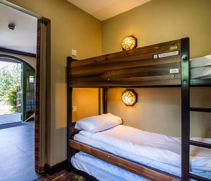 a bunk bed on a brown frame with lights on the wall