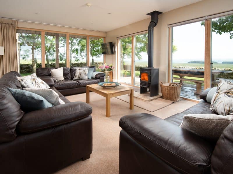 Cozy living room with fireplace and countryside view.