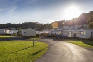 Sunset over peaceful caravan park with green lawns.