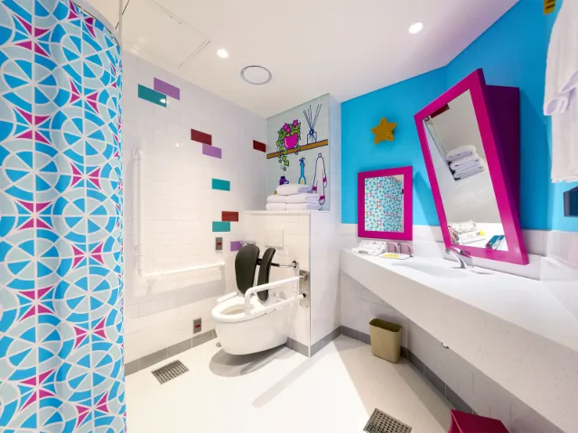 Colorful, modern bathroom with vibrant decor and accessibility features.