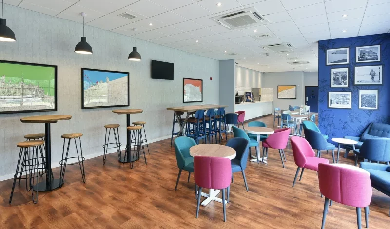 Modern cafe interior with colorful chairs and decor.