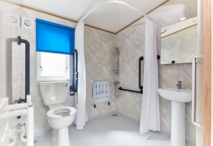 Accessible bathroom with support rails and walk-in shower.