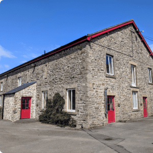 Historic stone building with red doors under blue sky.