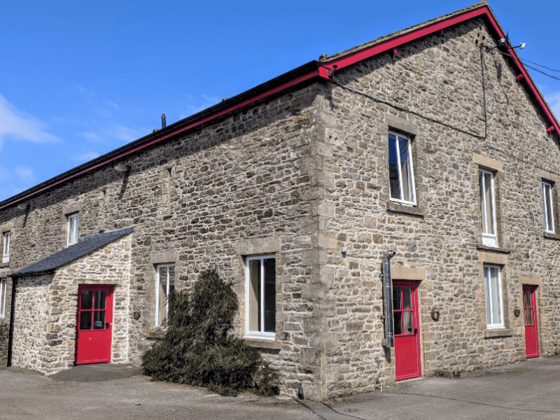 Historic stone building with red doors under blue sky.