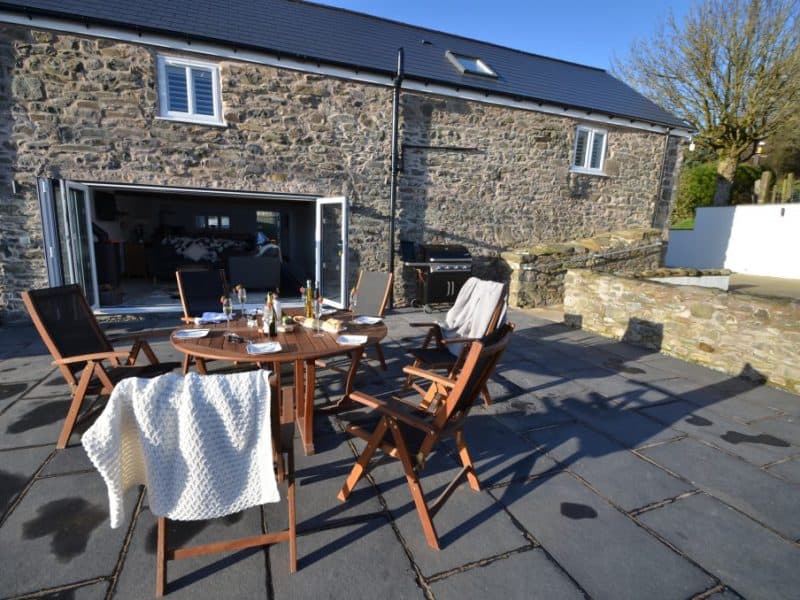 Outdoor dining setup at stone house patio.