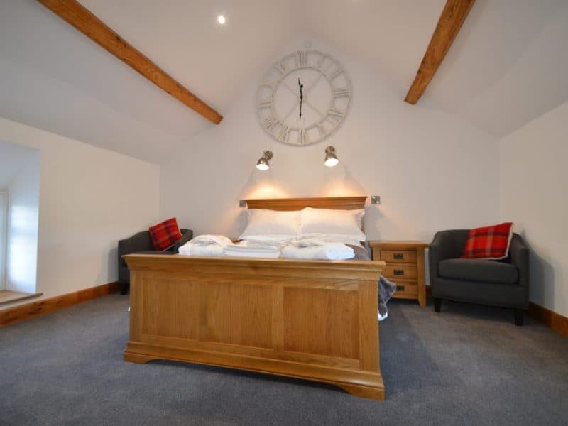 Cozy bedroom with wooden beams and modern decor.