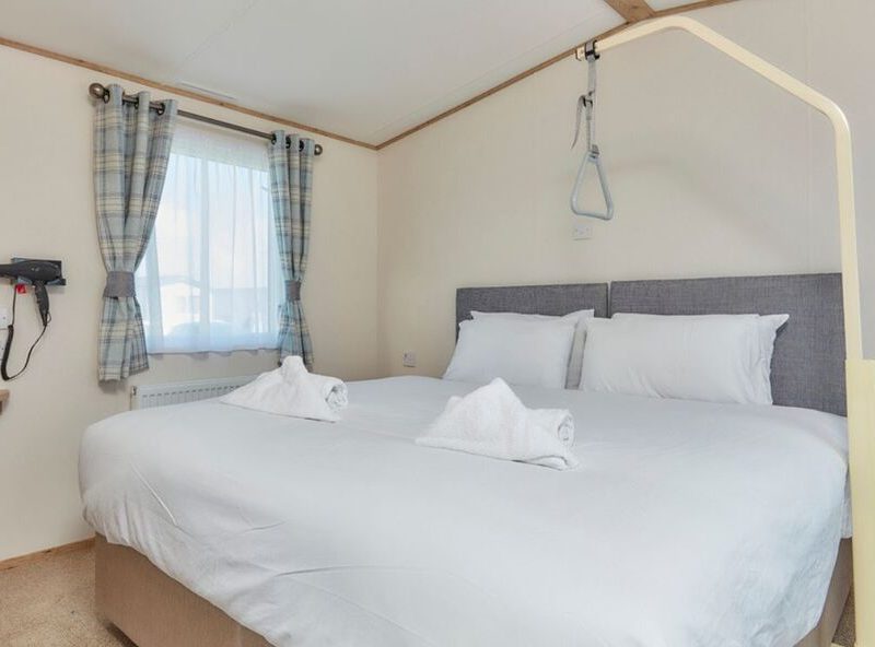 Cozy hotel room with large bed and sea view window.