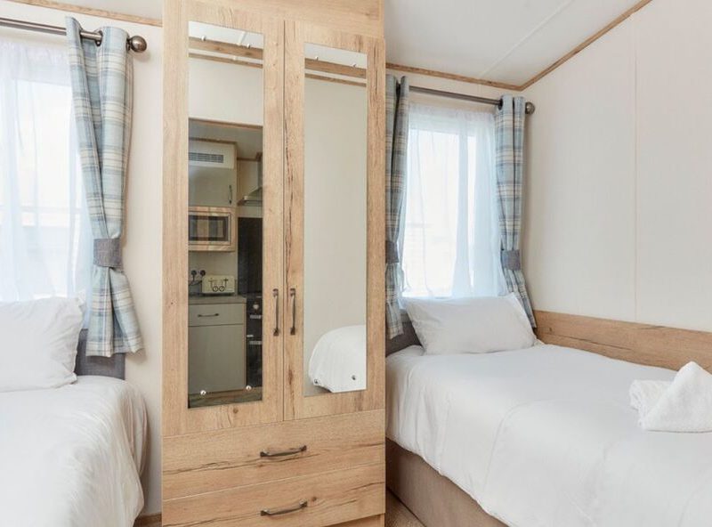 Cozy twin bedroom with wooden furniture and natural light.