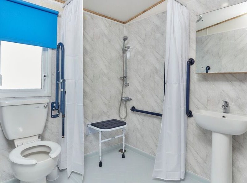 Accessible bathroom with grab bars and shower seat.