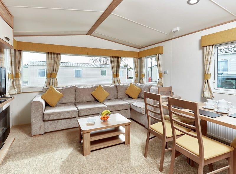 Cozy caravan interior with sofa and dining area.