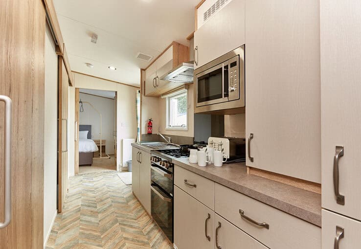 Compact modern kitchenette in well-appointed mobile home.