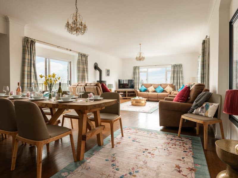 Bright, cozy living room with dining area and scenic view.