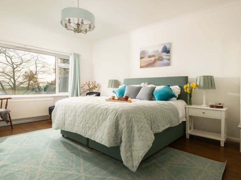 Bright, cozy bedroom with scenic window view and modern decor.