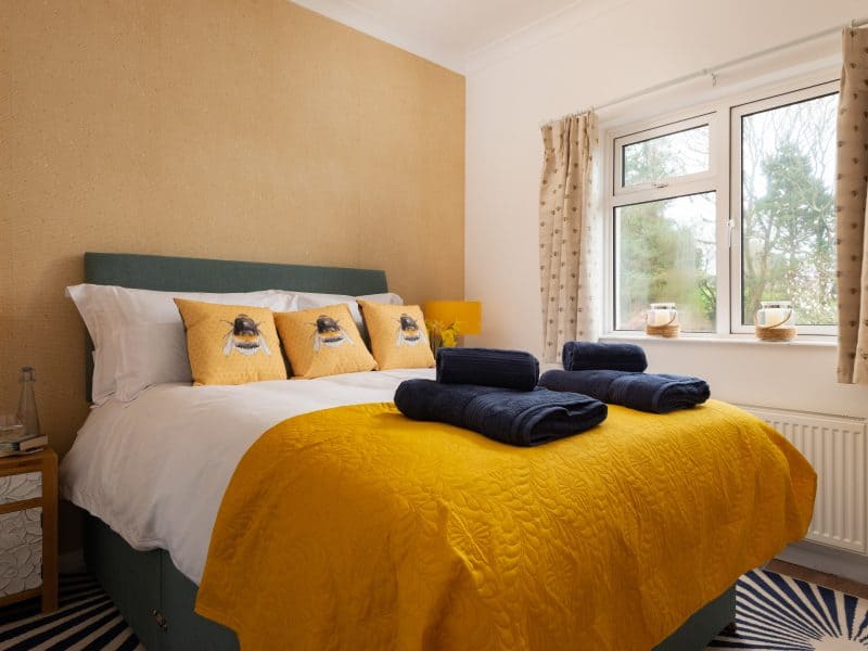 Cozy bedroom with yellow bedding and dog-themed pillows.