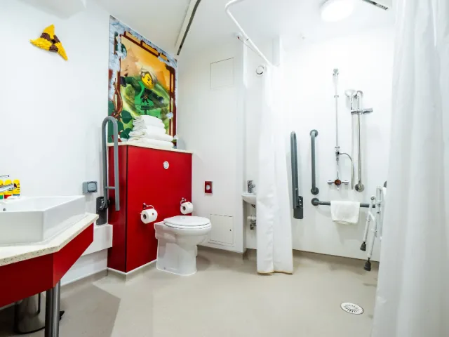 Accessible bathroom with colorful decor and assistive features.