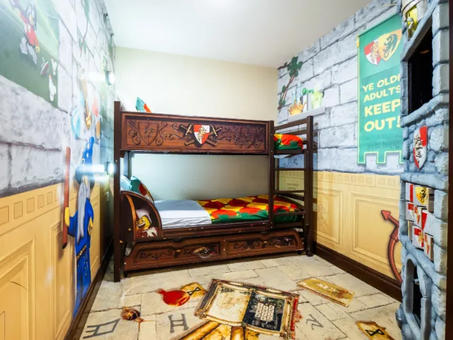 Themed kids' bedroom with castle bunk beds and colorful decor.