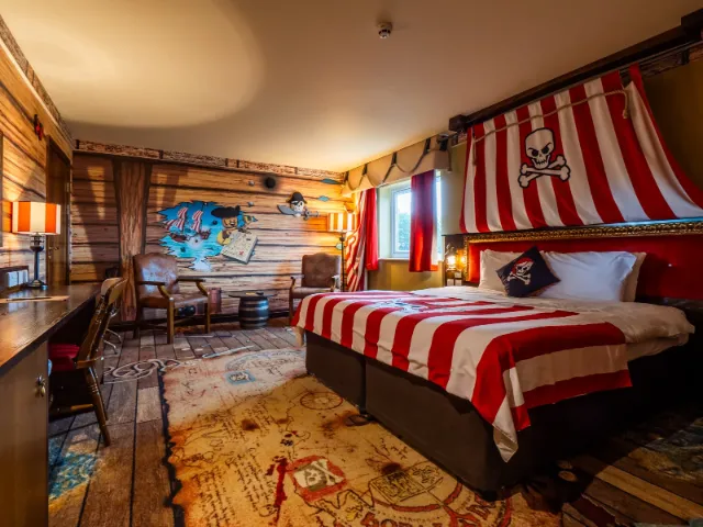 Pirate-themed bedroom with striped bedding and nautical decor.