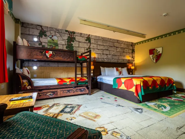 Medieval-themed hotel room with bunk beds and colorful decor.