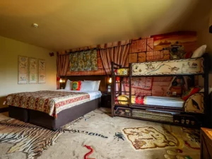 Adventure-themed hotel room with bunk beds and map decor.