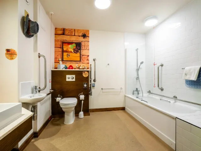 Accessible modern bathroom with safety rails and artistic decor.