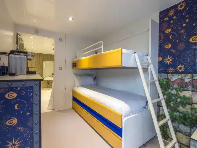 Compact hostel room with colorful bunk beds and modern decor.