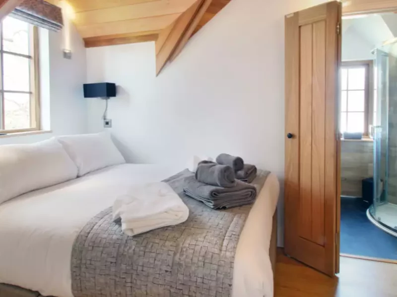 Cozy attic bedroom with shower and wooden accents.