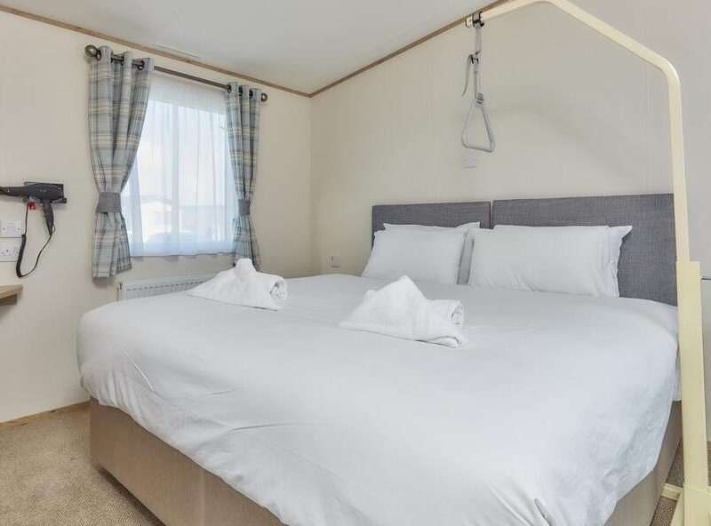 Cozy hotel room with large bed and bright window view.