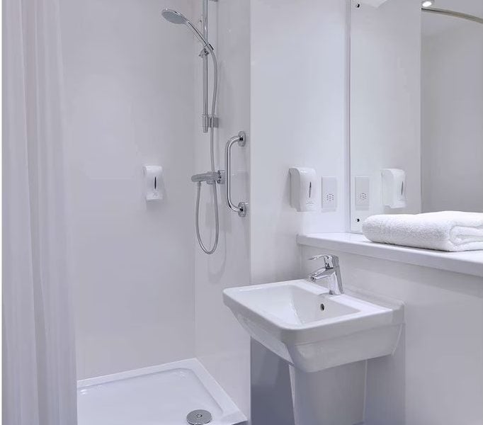 Modern white bathroom with shower and blue floor.