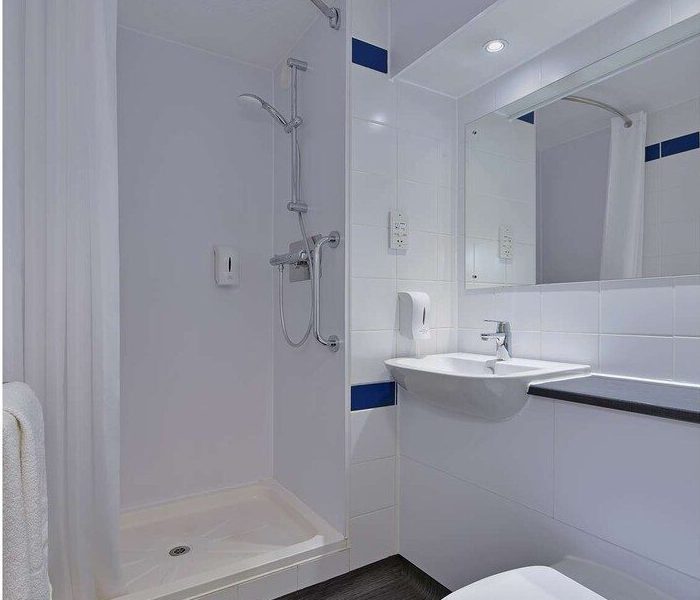 Modern hotel bathroom with shower and mirror.