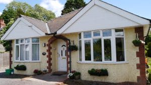 Charming bungalow with white doors and flower baskets.