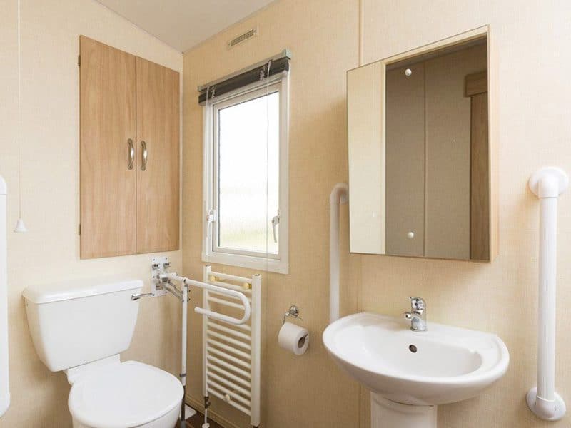 Accessible bathroom with safety rails and modern fixtures.