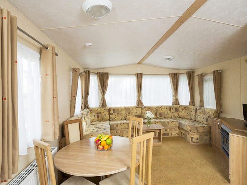 Spacious, well-lit caravan interior with comfortable seating.