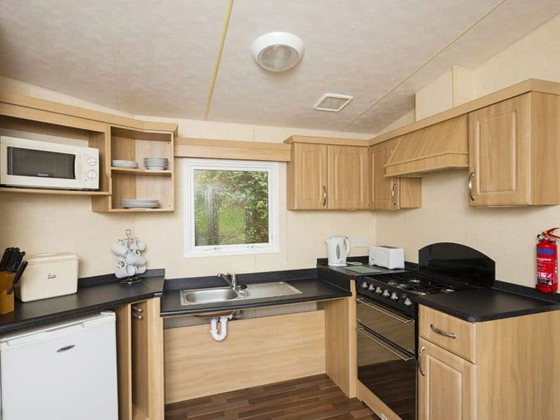 Compact kitchen with appliances, cabinets, and window view.