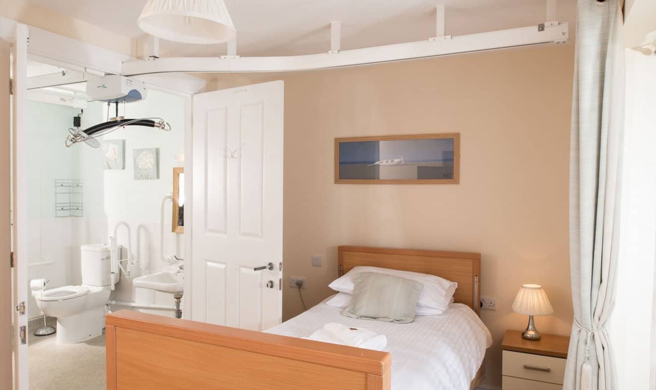 Accessible bedroom with overhead patient lift system.