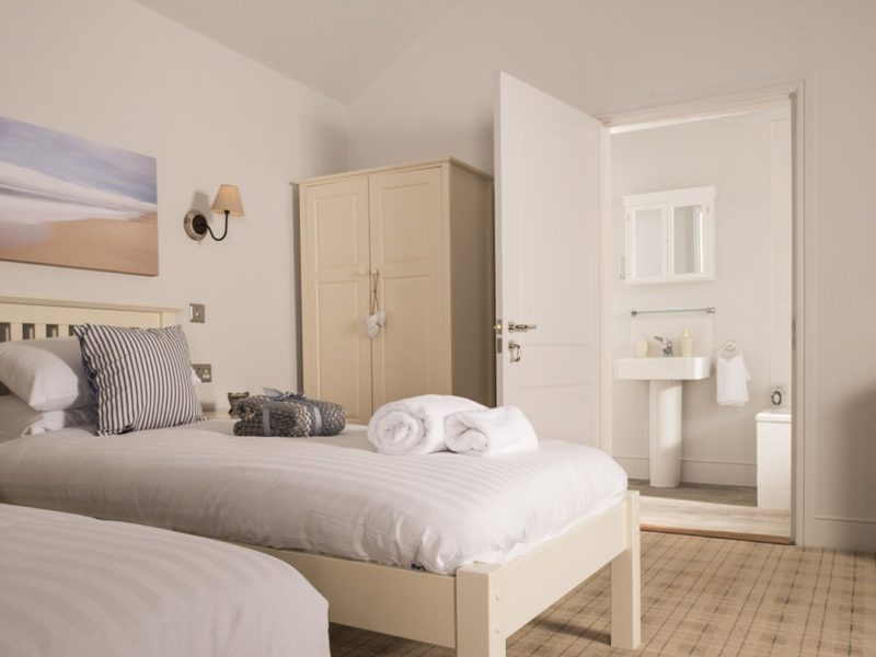 Elegant, minimalist bedroom with open ensuite bathroom.