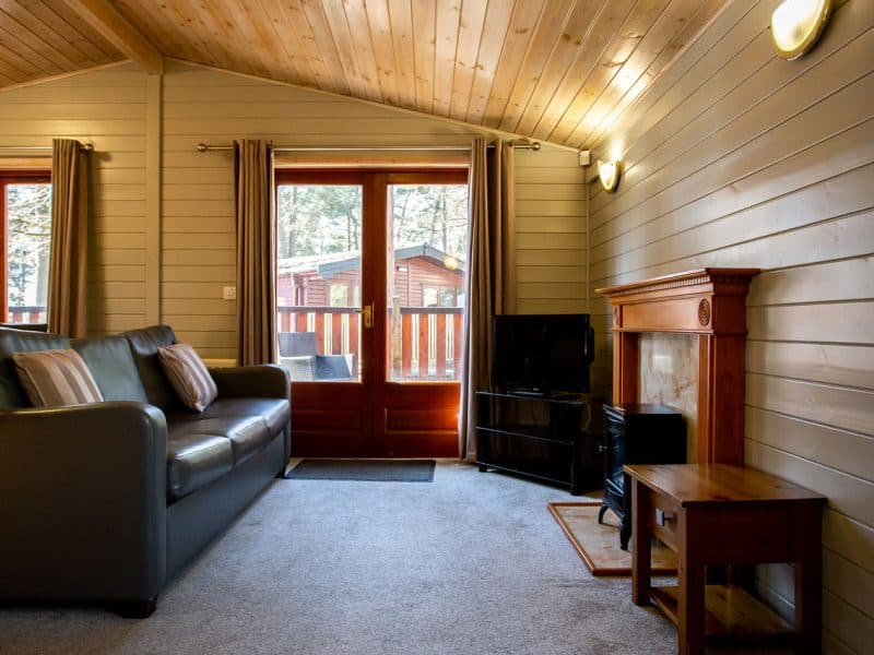 Cozy cabin interior with sofa and scenic window view.