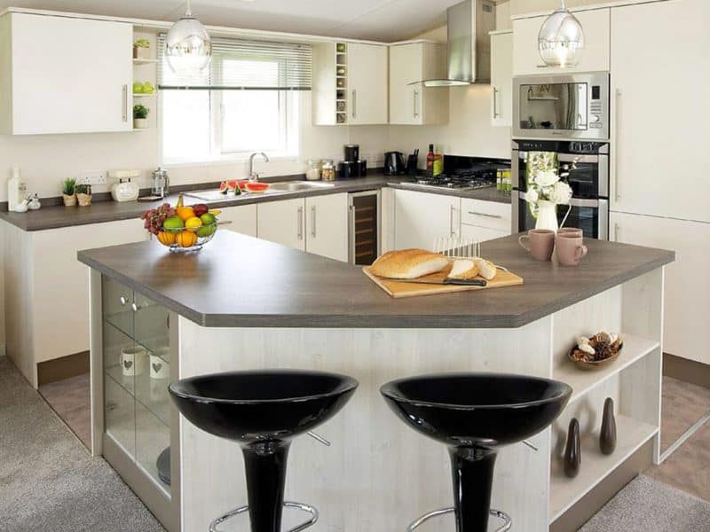 Modern kitchen with island and stylish black bar stools.