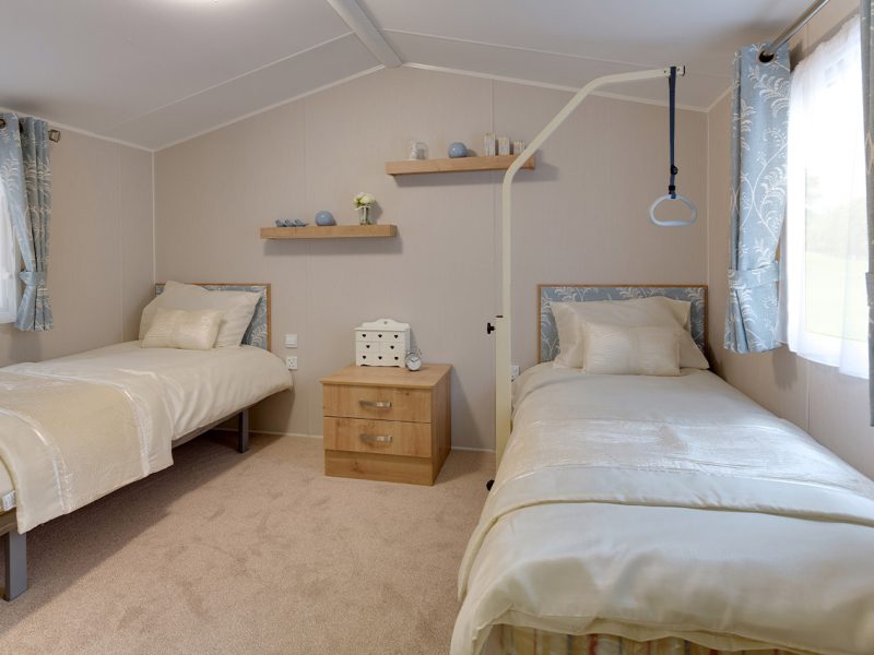 Twin bedroom with coordinated decor and natural light.