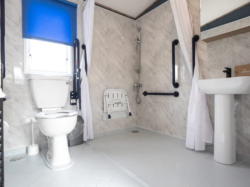 Accessible bathroom with grab bars and support equipment.