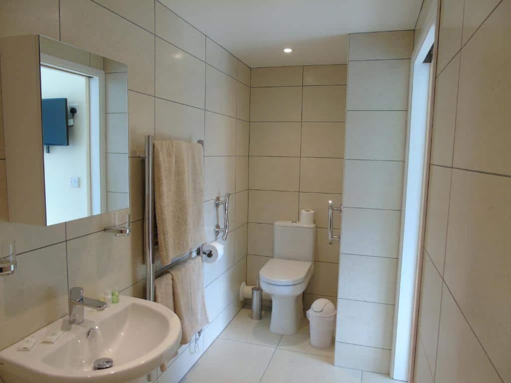 Modern bathroom with beige tiles and white fixtures