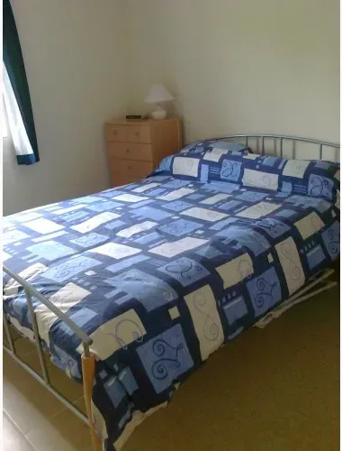 Single bed with patterned blue bedding in room