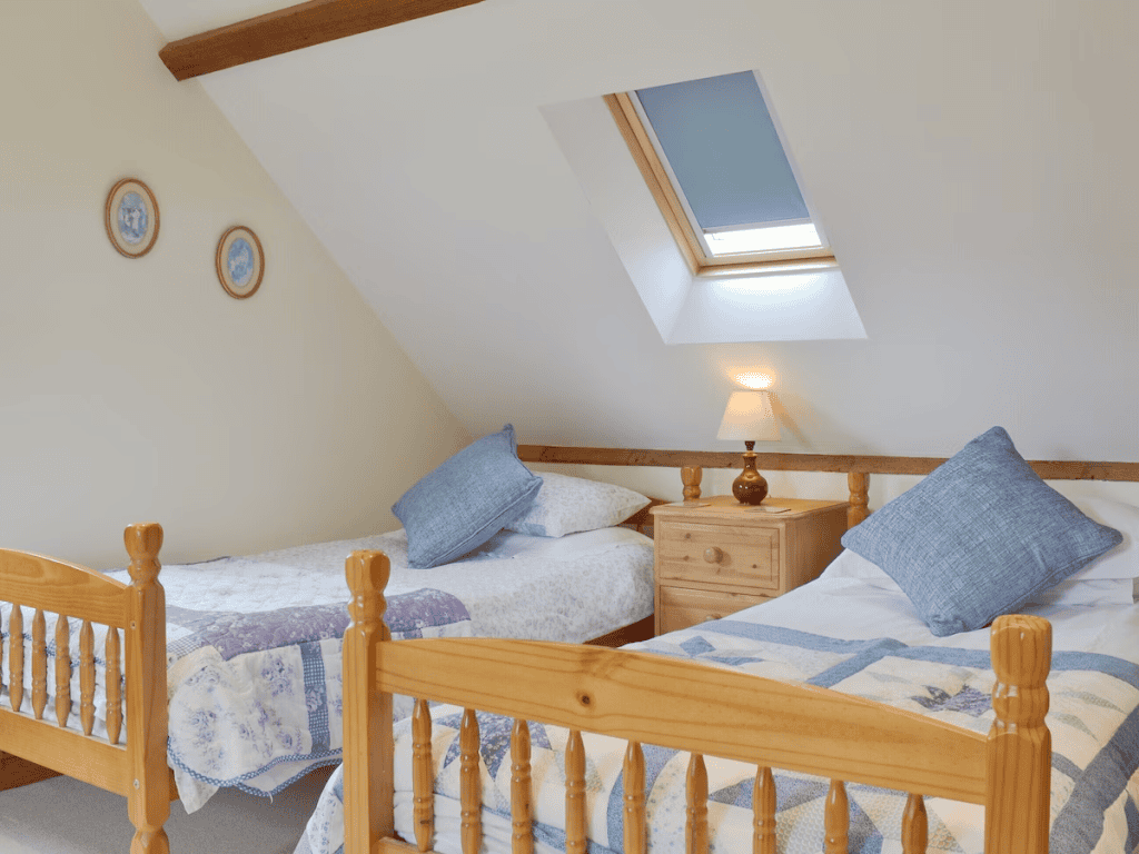 Cozy attic bedroom with twin beds and skylight