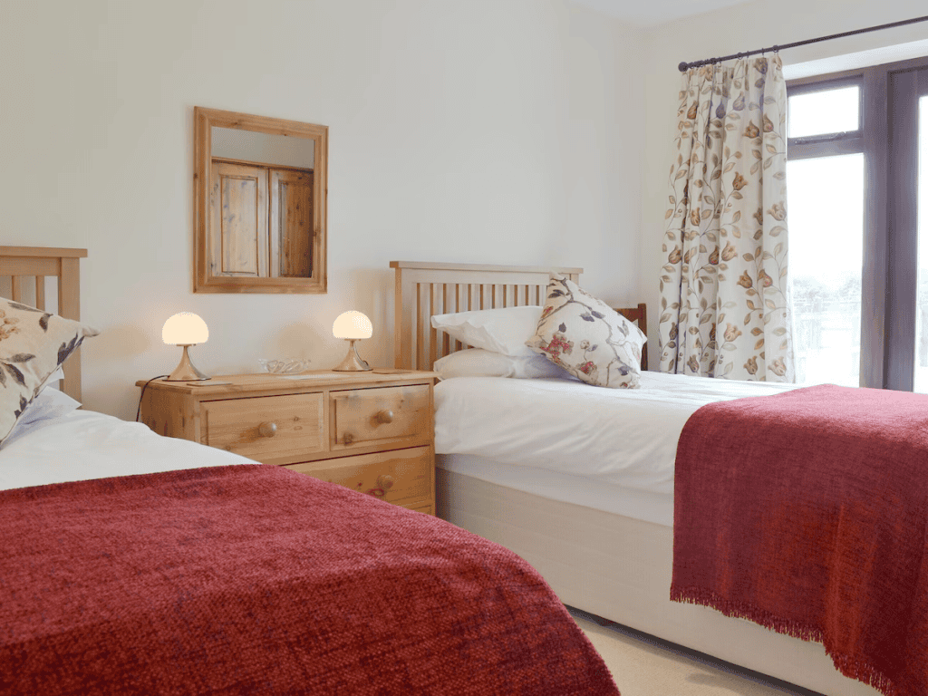 Bright bedroom with two beds and wooden furniture