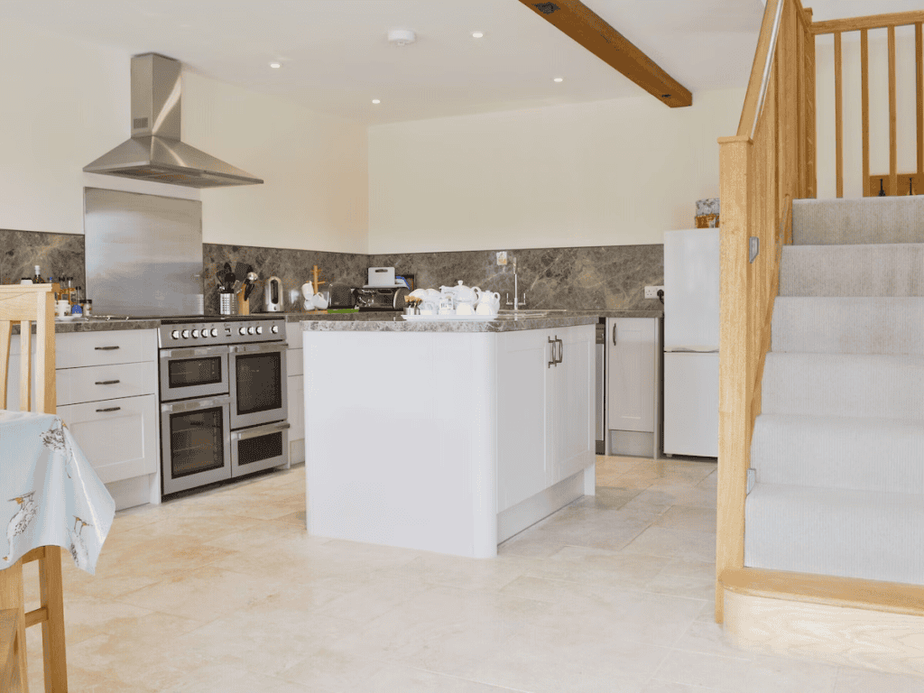 Modern kitchen with island and wooden staircase